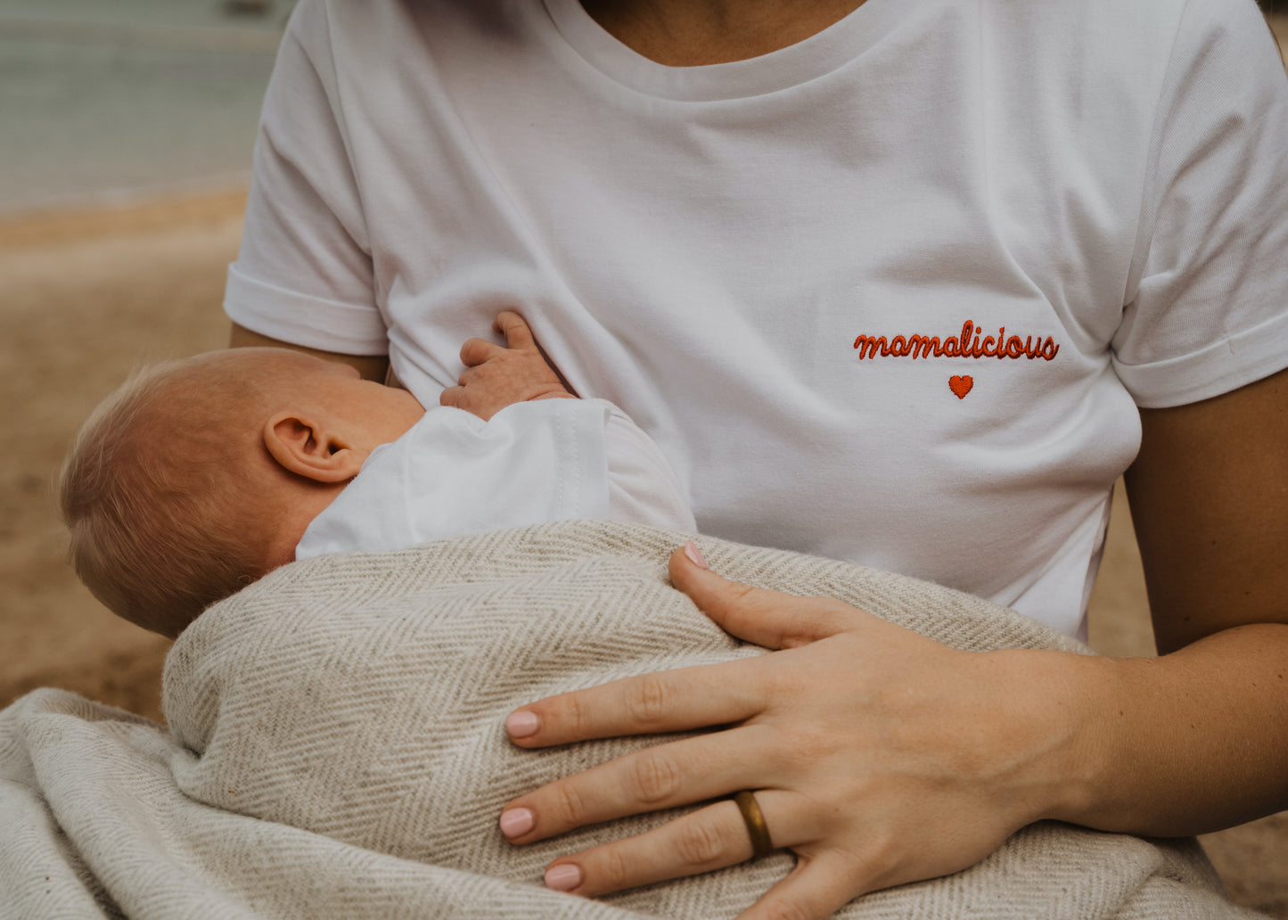 Tričko na dojčenie zo 100 % prvotriednej organickej bavlny s certifikátom GOTS a Oeko-Tex. Pretože sa oplatí pripomenúť, že všetky mamičky sú "mamalicious"! Biela farba Červená výšivka, nápis "mamalicious" so srdiečkom, bočné otvory na dojčenie na oboch stranách.